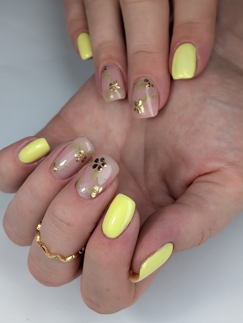 Gele gelpolish gecombineerd met naaktnagels met gouden bloem-nail-art, Nagelhuijs76